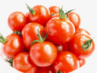 容器に入れたフレッシュなミニトマト、沢山のミニトマト、白背景