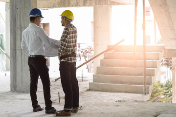 Asian contractor and engineer inspecting material in construction building.