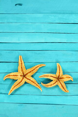 Orange starfish on blue rustic nautical pier boards. Summer, sea background. Concept of travel, vacation. Vertical and horizontal. Copy space