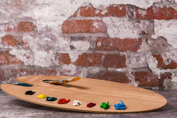 wooden palette with colored oil paint and brushes