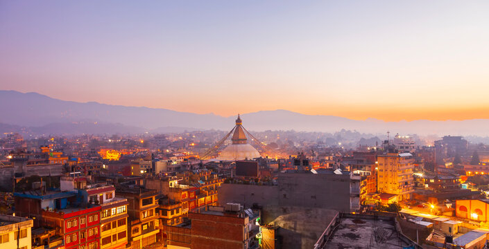 Sunset at the Boudhanath stupa Kathmandu Nepal.Colorful panorama cityscape in twilight sunset.Buddha temple in morning sunrise.Old town of Kathmandu with a Himalaya mountain range background. 