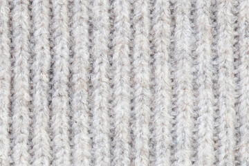 Knitwear background. White woolen fabric texture. Warm jumper closeup. Yarn textile backdrop. Handmade sweater texture. Gray cotton pattern.
