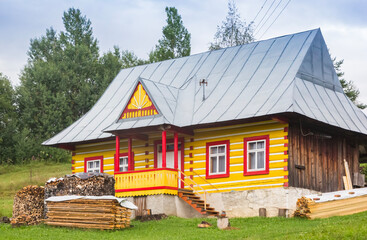 Fototapeta premium Colorful yellow and red timber house in Zdiar, Slovakia