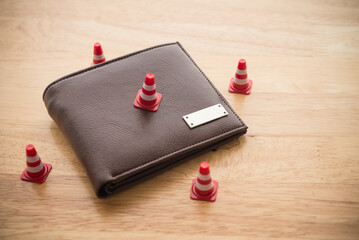 Close up under construction cone around leather wallet wooden background copy space. Personal...
