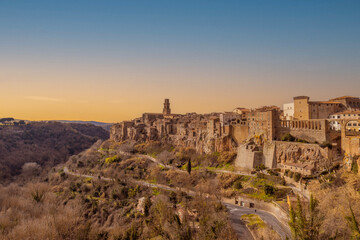 Fototapeta na wymiar Scorcio del bellissimo paese di Pitigliano all'alba, con le sue mura erette sul tufo