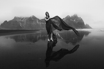 Happy lady wrapped with chiffon on beach monochrome scenic photography. Picture of person with...