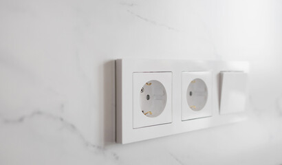  group of white european electrical outlets and a switch located