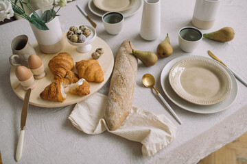 Closeup of delicious breakfast. Elegant crockery and flowers in vase on dining table. Aesthetic still life.