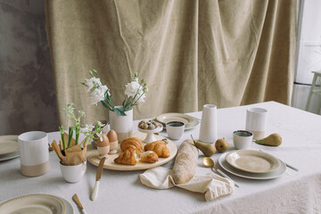 Delicious table setting for family meal. Elegant crockery and flowers on dining table. Easter background. Holiday meal.