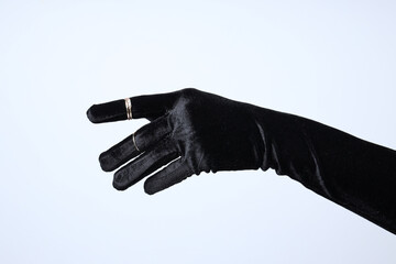 Female hand in black glove with rings on white background