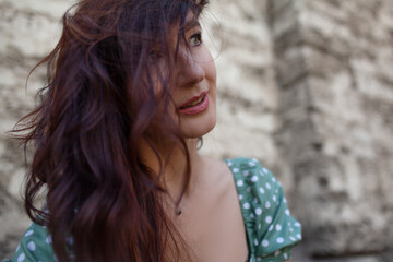 A beautiful girl with a long brown hair of 35 walks around the city