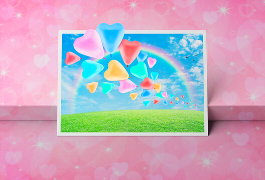 Colorful love heart balloon with green grass field over blue sky, rainbow and birds postcard on light pink heart love box podium, Valentines day concept, 3D rendering