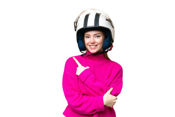Young pretty woman with a motorcycle helmet over isolated chroma key background pointing to the side to present a product
