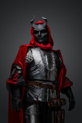 Portrait of medieval cultist with red cape and black mask dressed in steel armor.