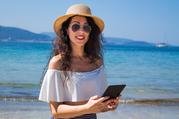 young tourist woman with digital tablet on the beach