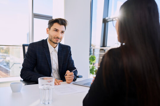 Recruiter with document talking to candidate in interview at office