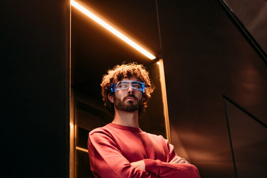 Young man wearing smart eyeglasses standing in elevator