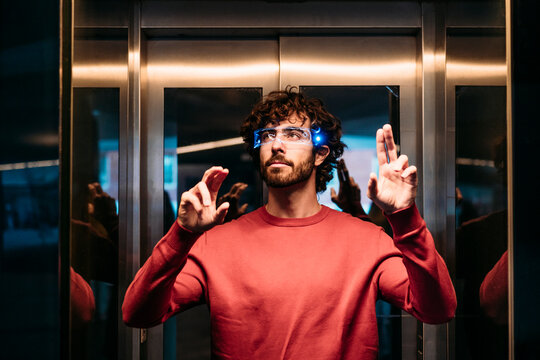 Man wearing smart eyeglasses gesturing in elevator