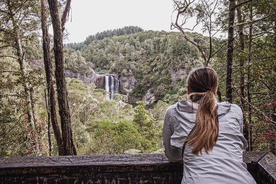 A young woman looks out over Hunua Falls, New Zealand