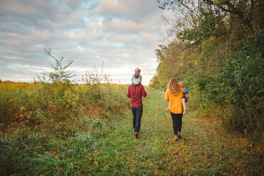 A family walk together in at sunset by a prairie full of wildflowers