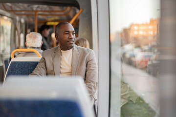 Thoughtful businessman looking through window in tram
