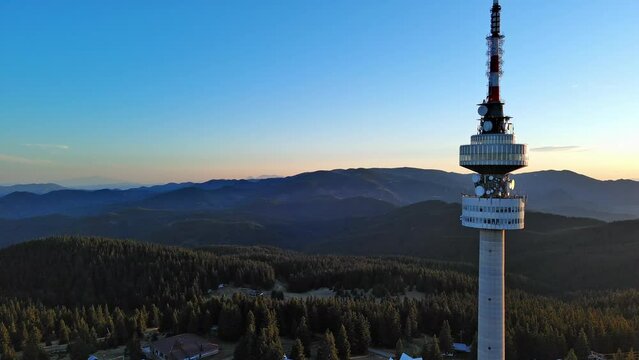 Tower Snezhana on peak of Snezhana covered with spruce forests in Rhodope mountains