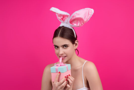 Portrait of young girl feeling happy, celebrating Easter, wear rabbit ears hold painted eggs. Young woman in studio wearing bunny ears. Happy Easter concept. Happy cheerful woman with bunny ears.