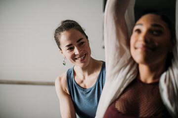 smiling personal trainer helps her female client with fitness