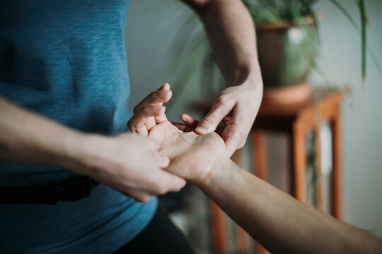 Close up of Massage therapist massaging the hand of a patient.