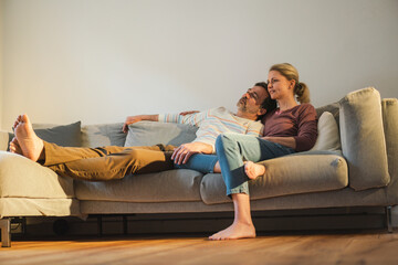Mature couple spending leisure time resting on sofa at home