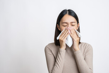 Portrait of beautiful young asian sick woman over isolated white background being wrapped in scarf...