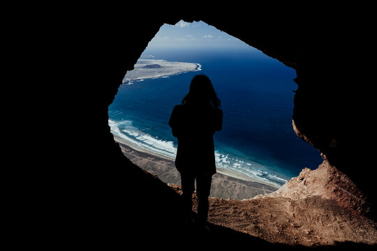 Silhouette of a man from a cave in the cliffs of Famara in Lanzarote