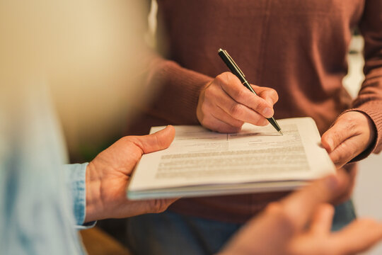 Hand Of Mature Woman Filling Form With Pen