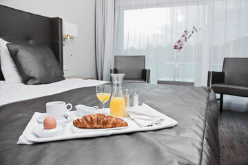 breakfast tray on a bed in a luxury hotel room