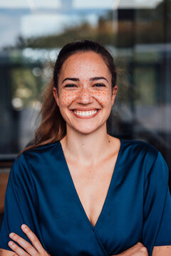 Cheerful young businesswoman with dots on face in office