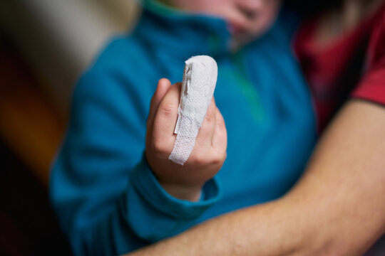 Crop child showing bandaged finger