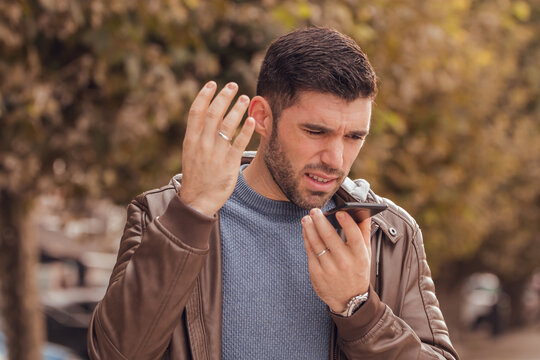 young man sending a voice message by mobile phone