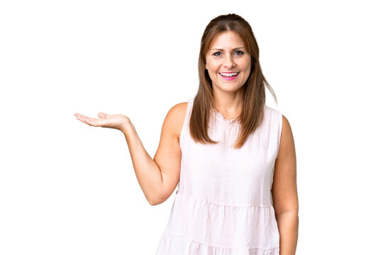 Middle age woman over isolated background holding copyspace imaginary on the palm to insert an ad