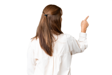 Middle age woman over isolated background pointing back with the index finger