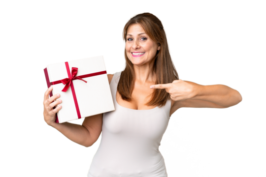 Middle age caucasian woman holding a gift over isolated background and pointing it - Powered by Adobe