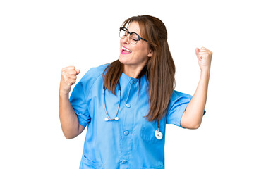 Middle age nurse woman over isolated background celebrating a victory