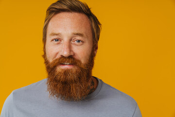 Fototapeta premium Bearded man posing at camera while standing isolated over background