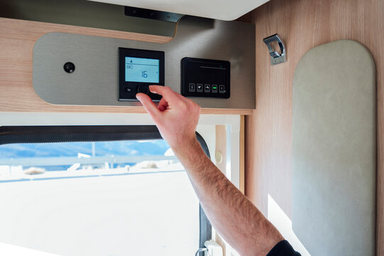 Hand of man adjusting AC temperature in motor home
