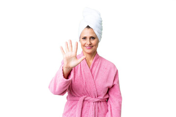 Middle age caucasian woman in a bathrobe over isolated background counting five with fingers