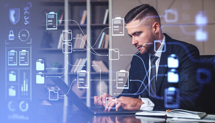 Businessman using laptop, document management system hologram