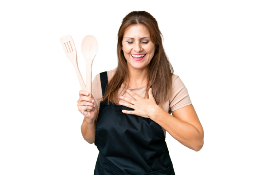 Middle age caucasian woman holding a rolling pin over isolated background smiling a lot