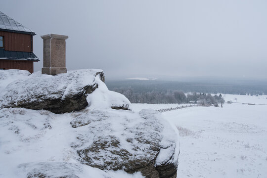 Foggy winter on Hirtstein Mountain, Satzung (Erzgebirge). German Ore Mountains with snow, hoar frost and a triangulation column with german inscription regarding land survey.