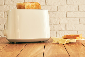 Fresh fried bread slices and thin cheese and toast for breakfast. Modern kitchen toaster. Cooking and homeware technologies backgrounds - obrazy, fototapety, plakaty