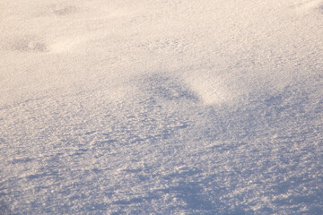 Snow in yellow light at sunset, background