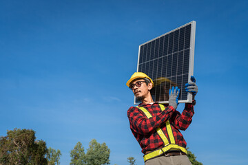 Engineers in helmets installing solar panel system outdoors. technician use a the Electric drill installing the solar panels at roof top of home and home office.